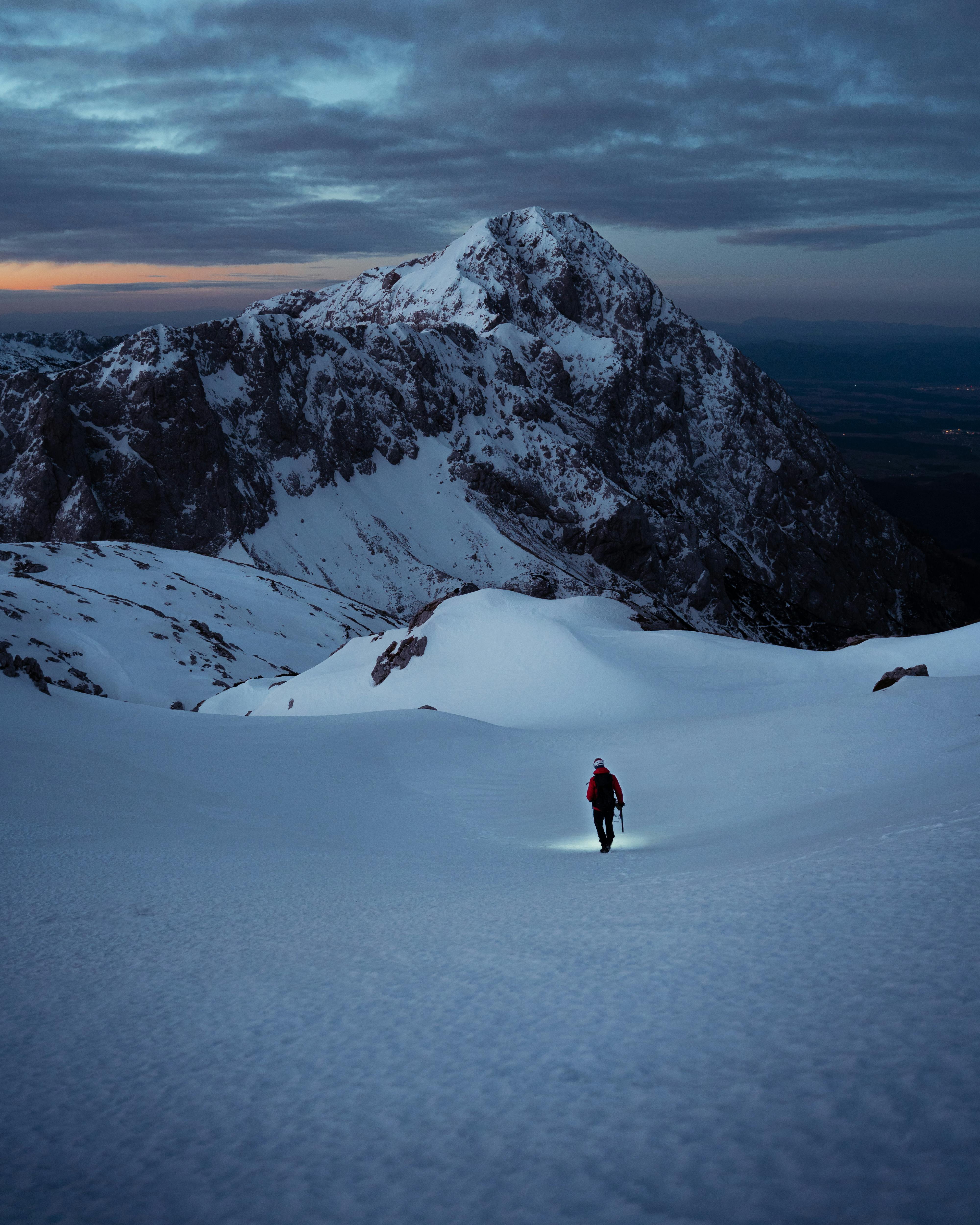 Walking in the snow on top of a mountain.