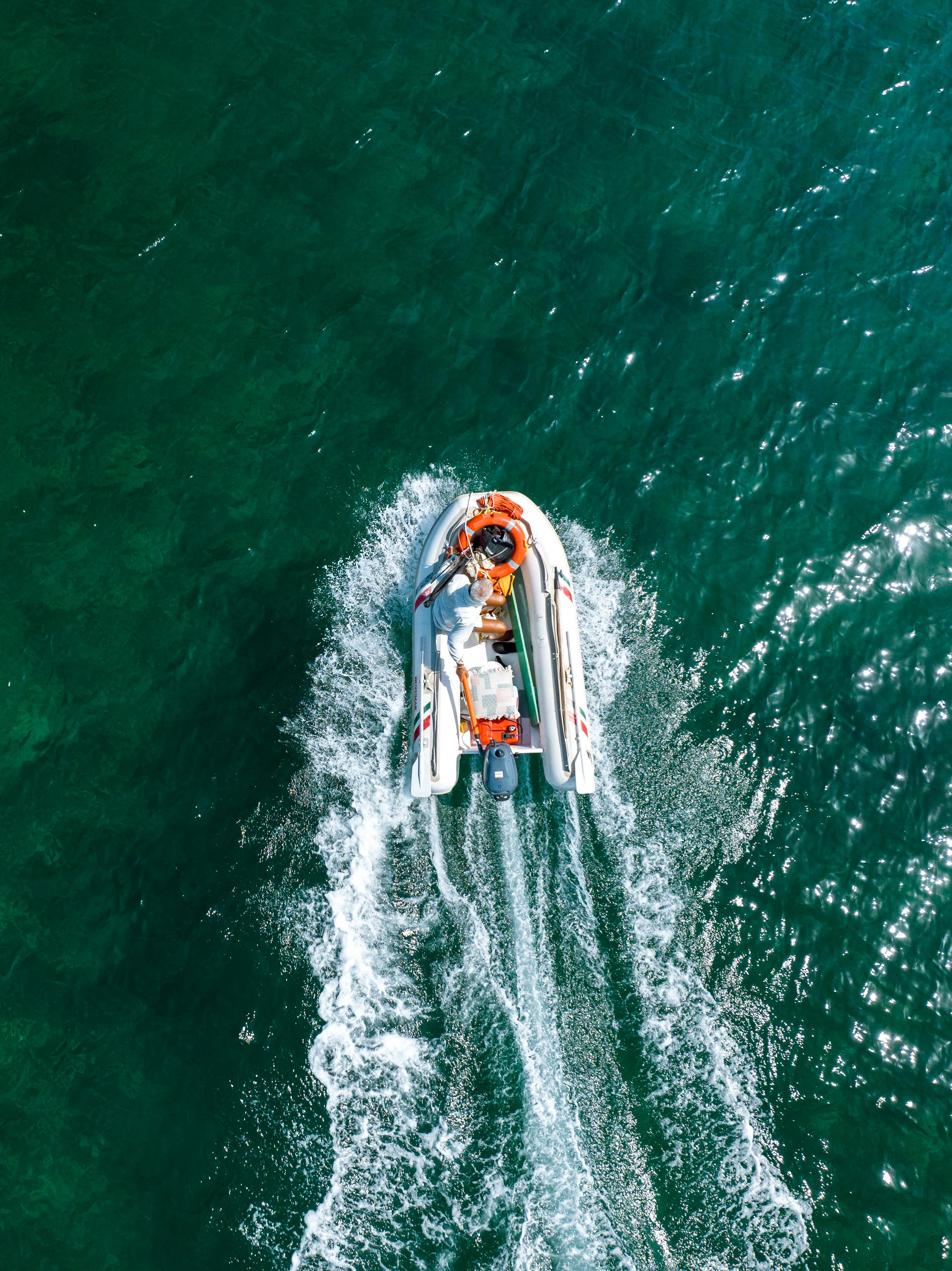 A boat sailing through azure blue water with soft waves.