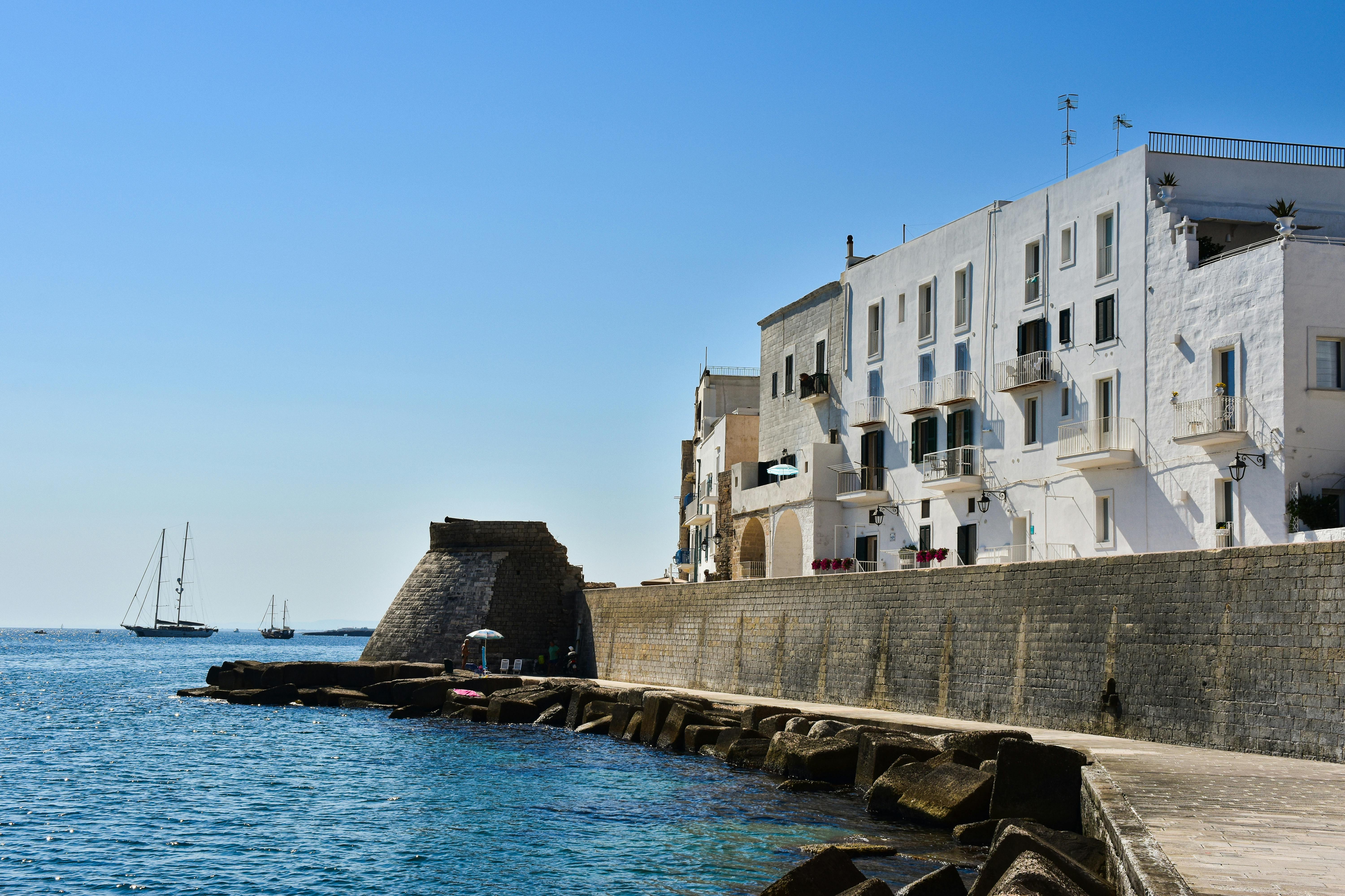 Azure blue sea water with white houses on a cliff during a sunny day.