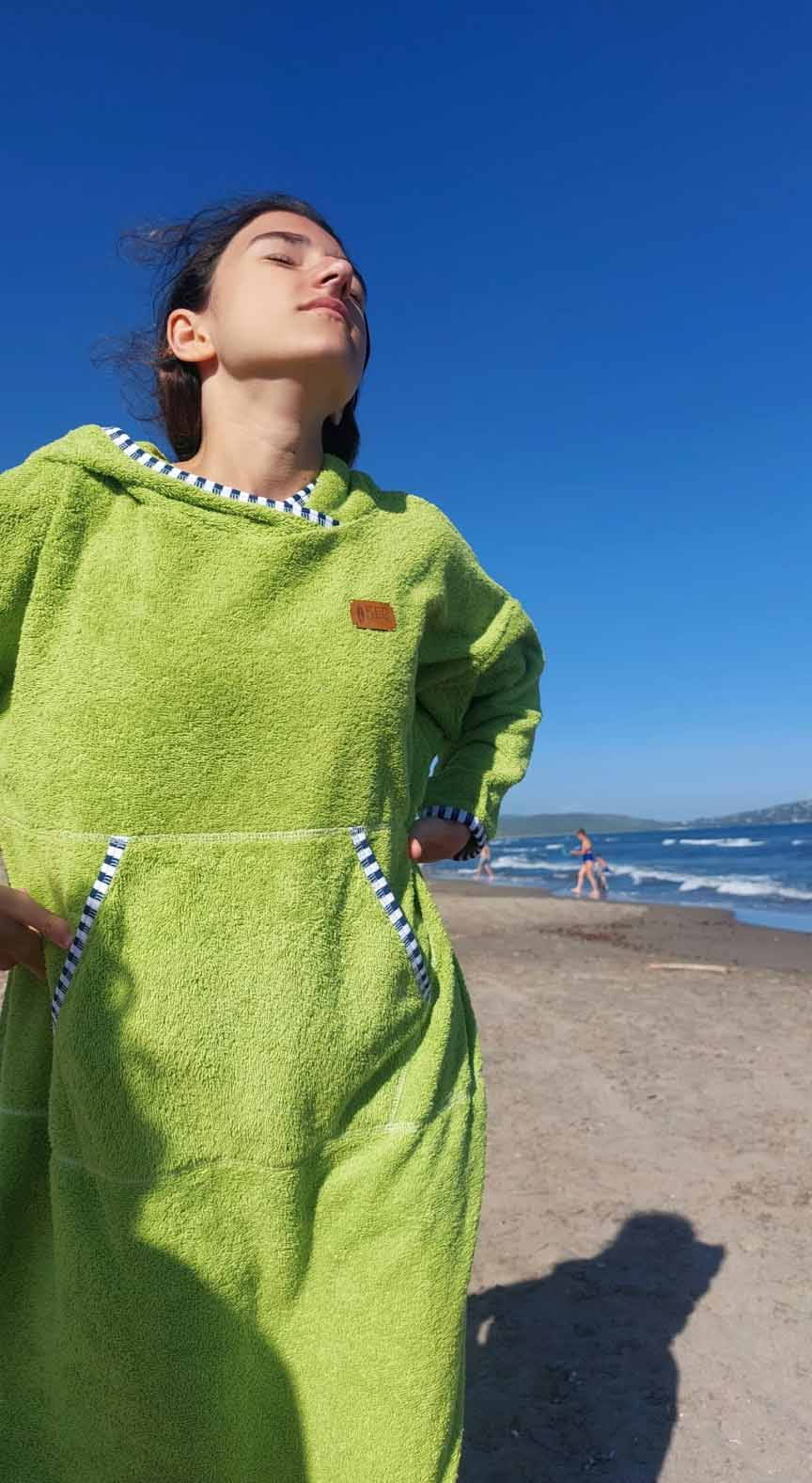A girl at the beach with a surfing puncho