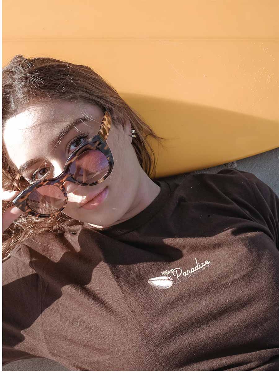 a girl with a brown t shirt and sun glasses