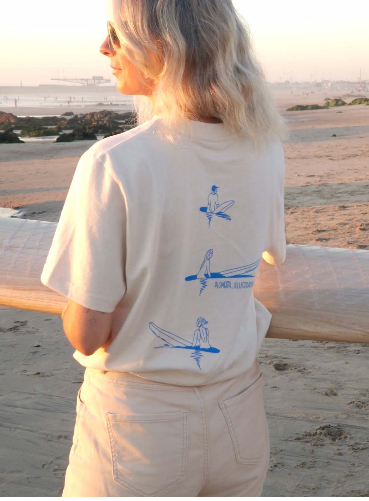 a woman wearing a white surfing style t shirt
