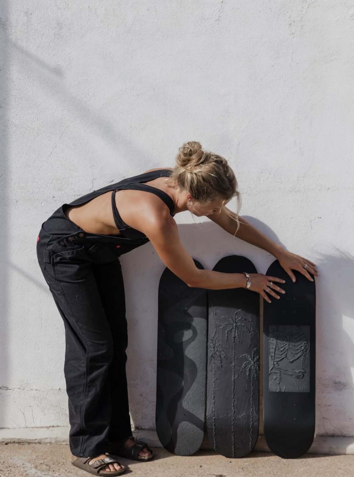 a women holding black sketboard deck