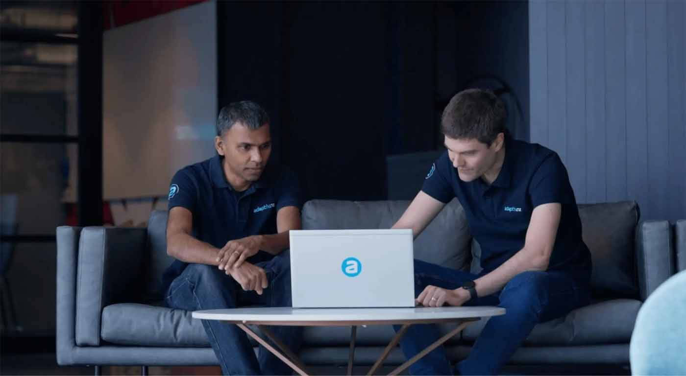 Two business professionals reviewing a laptop during a filmed brand video scene.