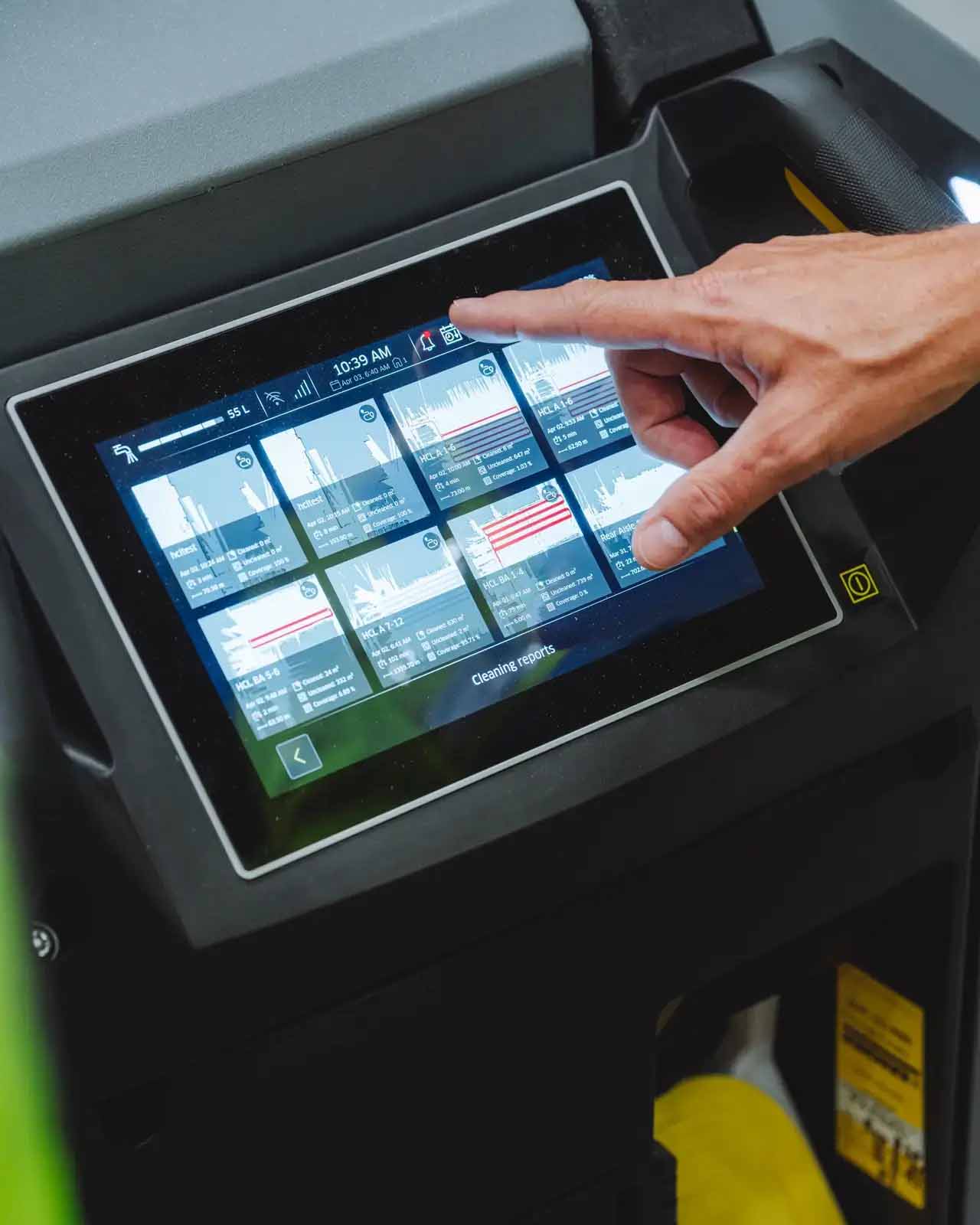 Hand using a touchscreen control panel on a Kärcher cleaning machine during a healthcare logistics case study video shoot.