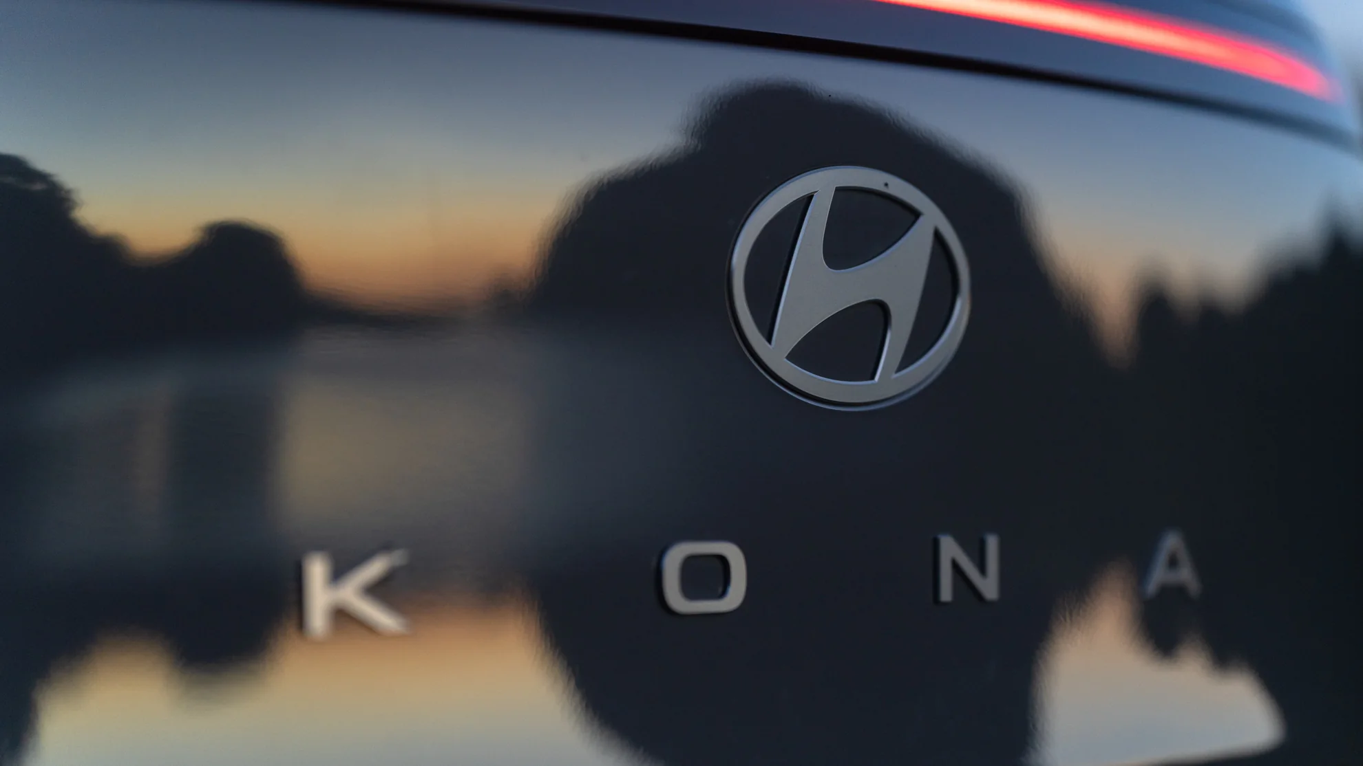 Hyundai logo and Kona lettering reflecting a sunset