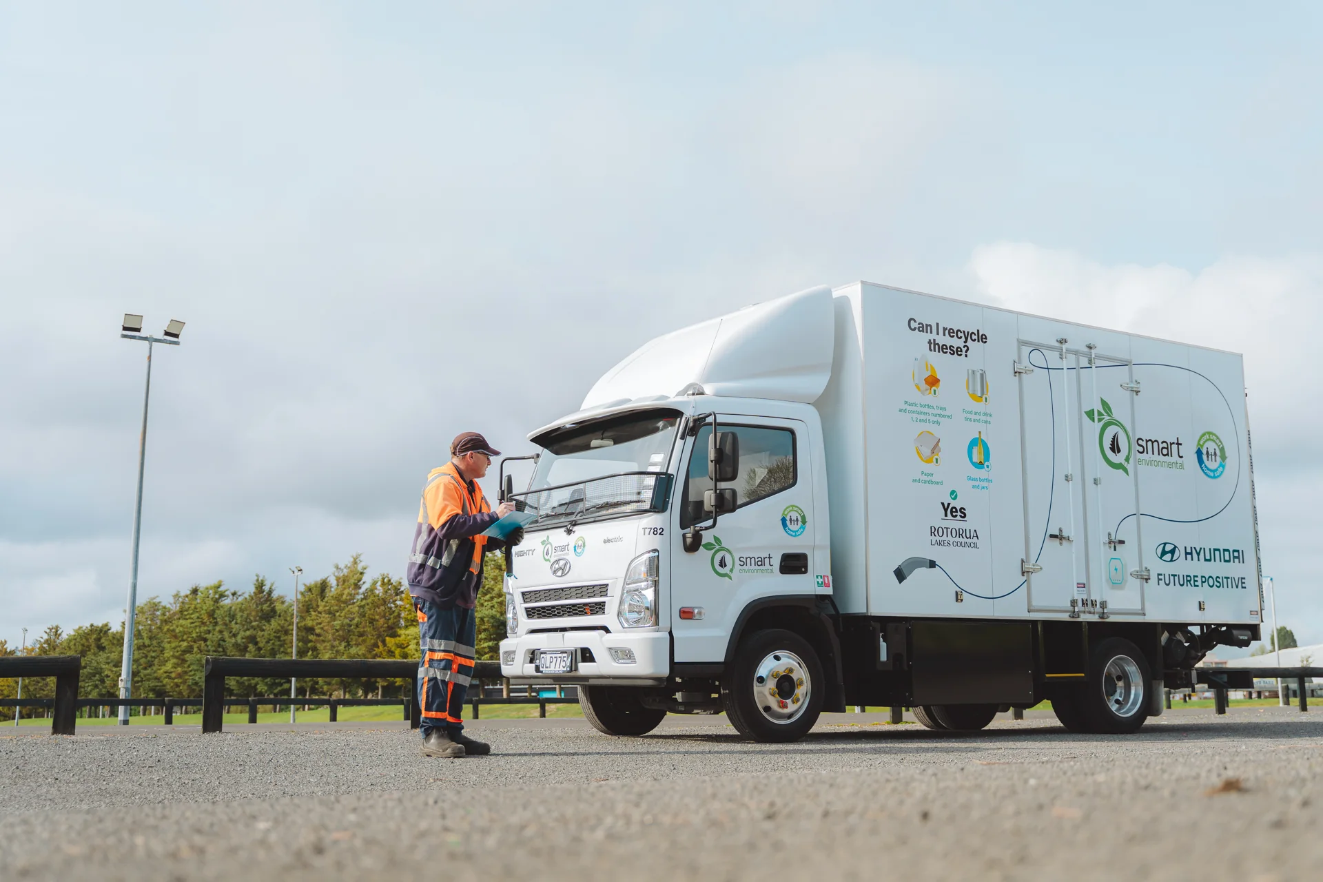 Worker in hi-vis beside a white Hyundai electric truck