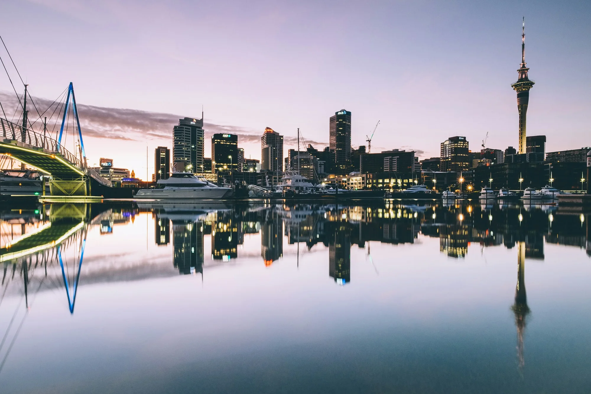 Auckland city skyline and Sky Tower reflected in the harbour at dusk