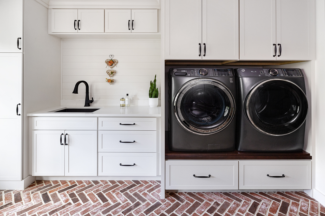The left side embraces practicality, serving as a well-appointed laundry section with an integrated sink and abundant storage to neatly house the home’s everyday utility needs