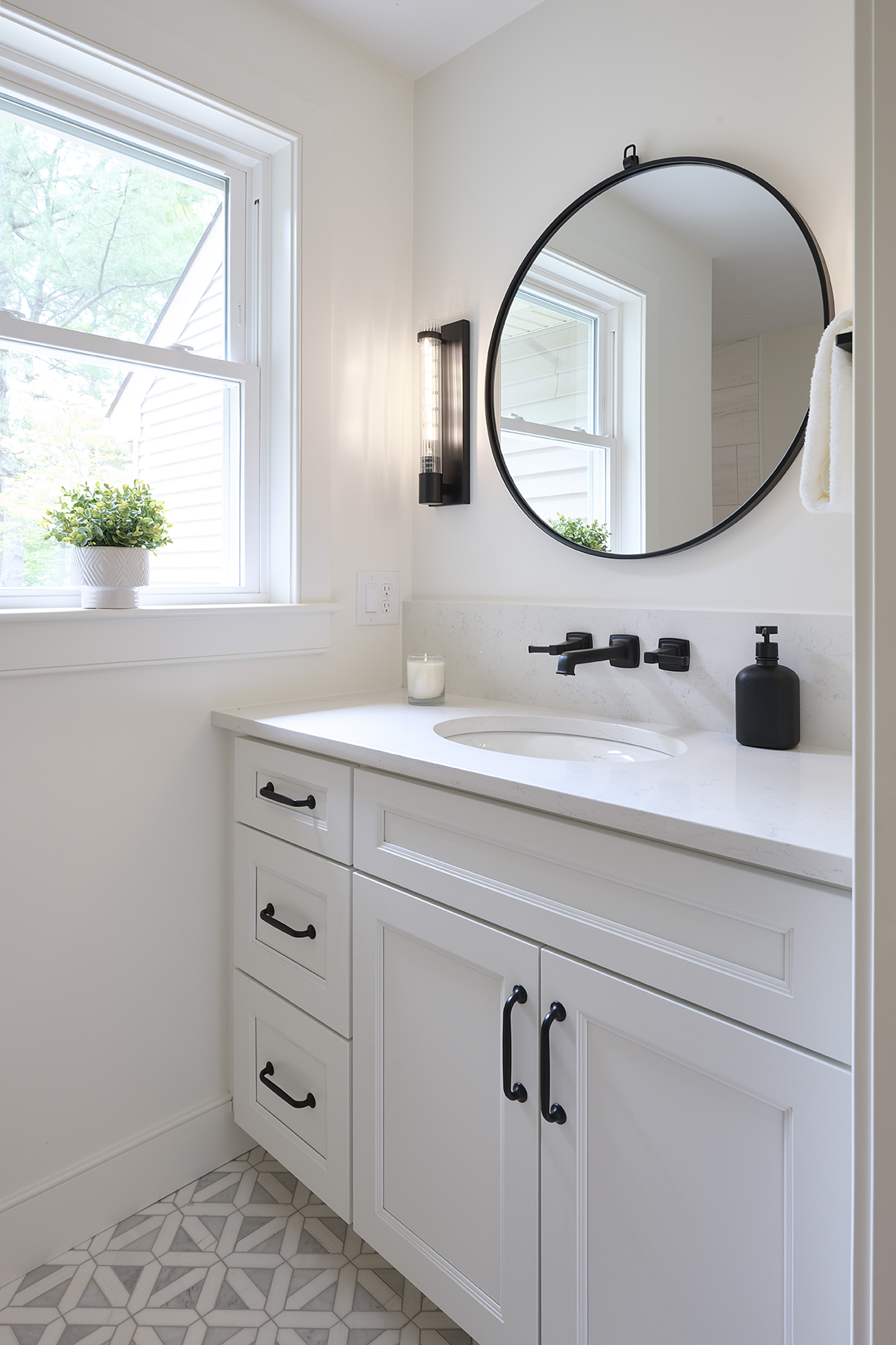  wall-mounted matte black fixtures and hardware punctuate the clean white Meriden cabinetry
