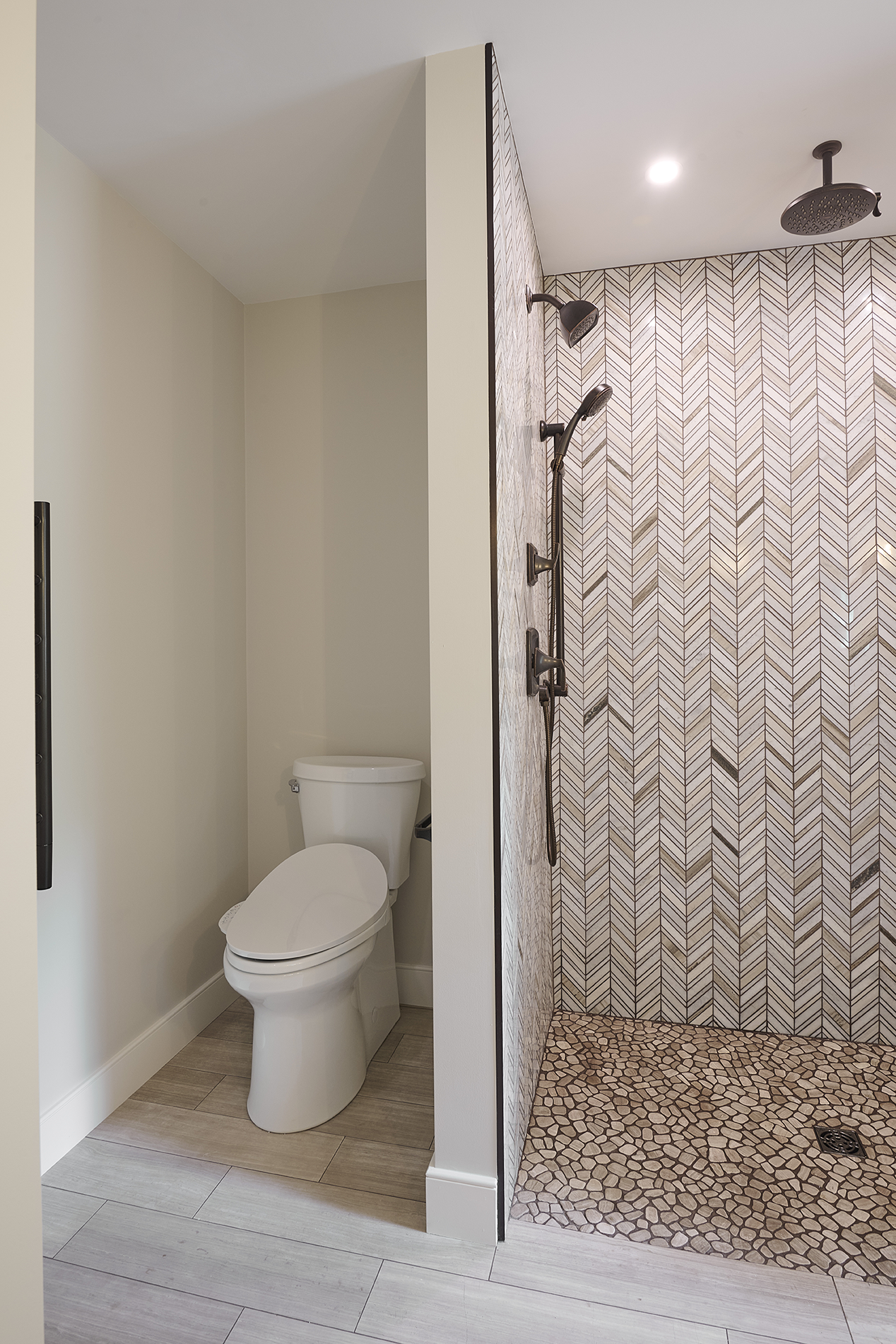 A multi-function shower system, including ceiling-mounted rain head, wall-mounted spray, and handheld wand, delivers customizable luxury, all in coordinating matte bronze
