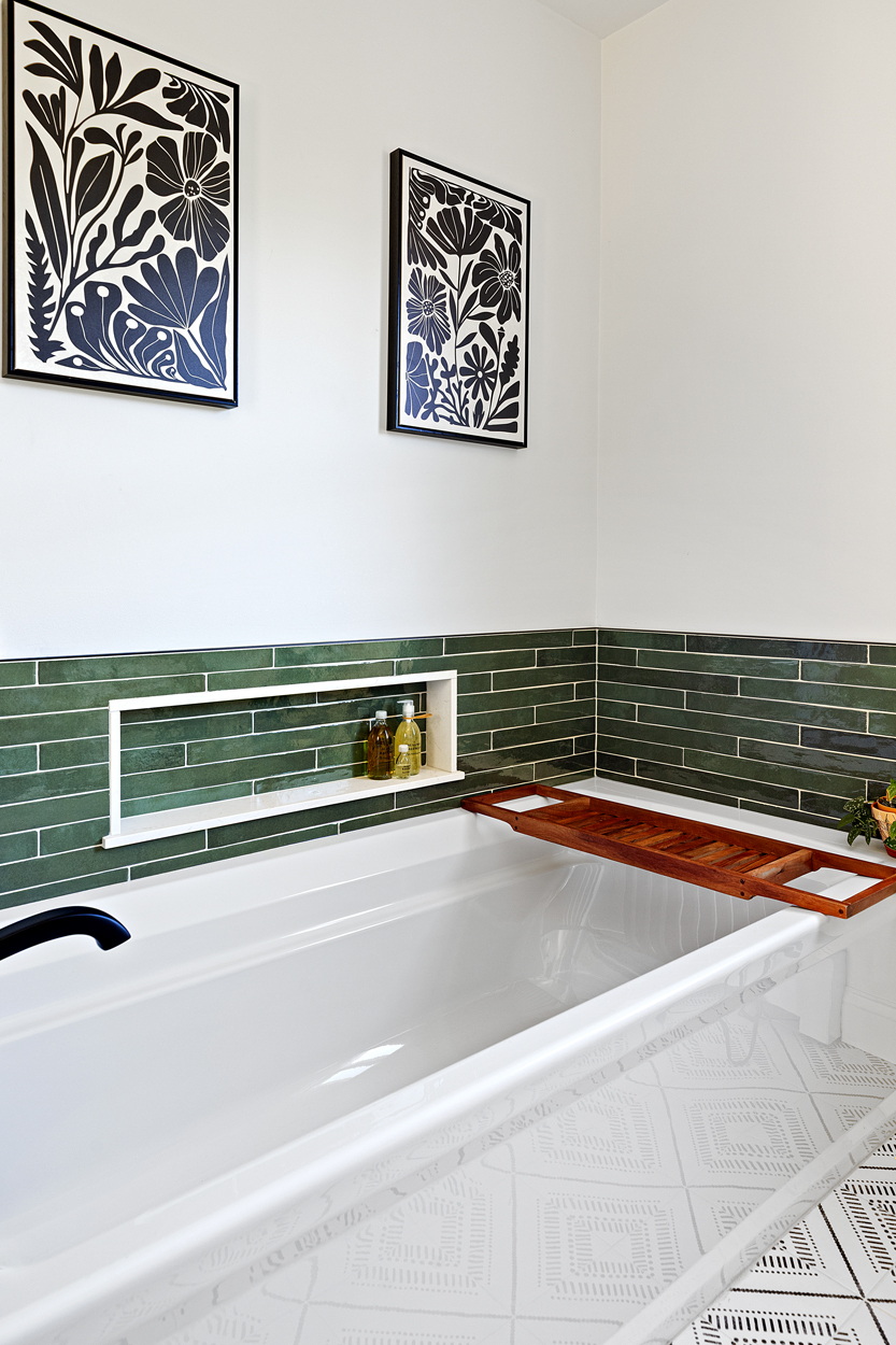 The Archer soaking tub in white anchors the surround with clean contrast, its crisp silhouette balancing the intensity of the surrounding tile. 