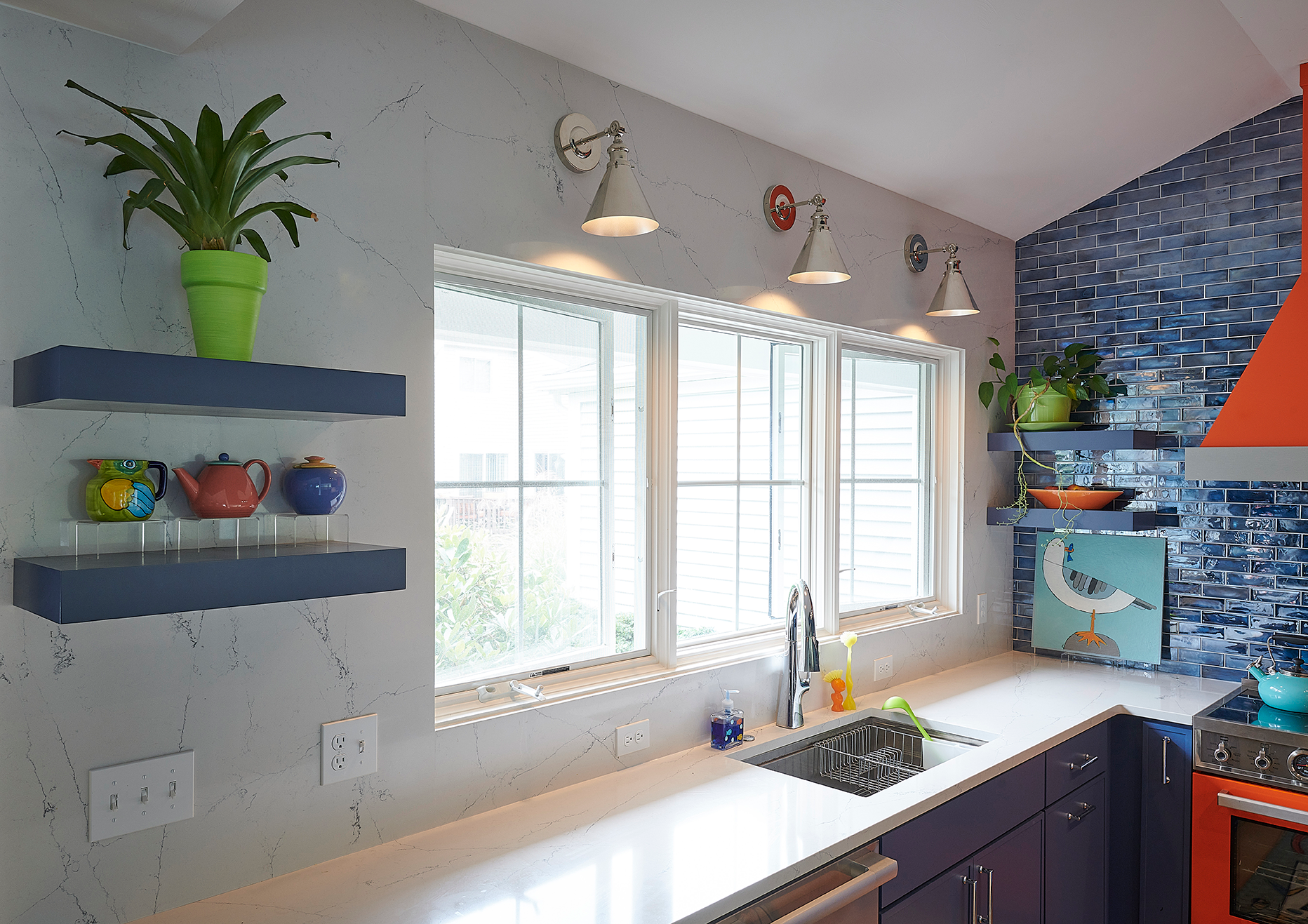 A trio of stunning windows set against a wall wrapped in flowing quartz, extending seamlessly to the countertops for an ultra-refined look.