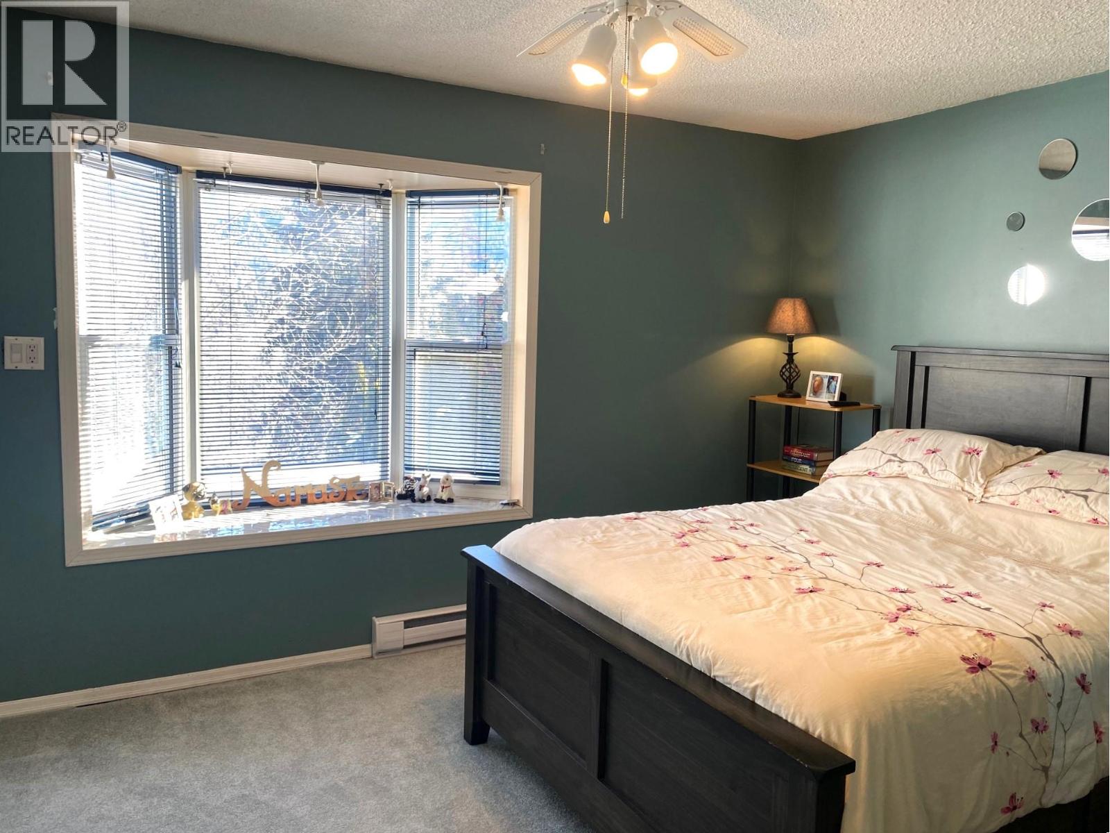 Primary bedroom with bay window overlooking the backyard