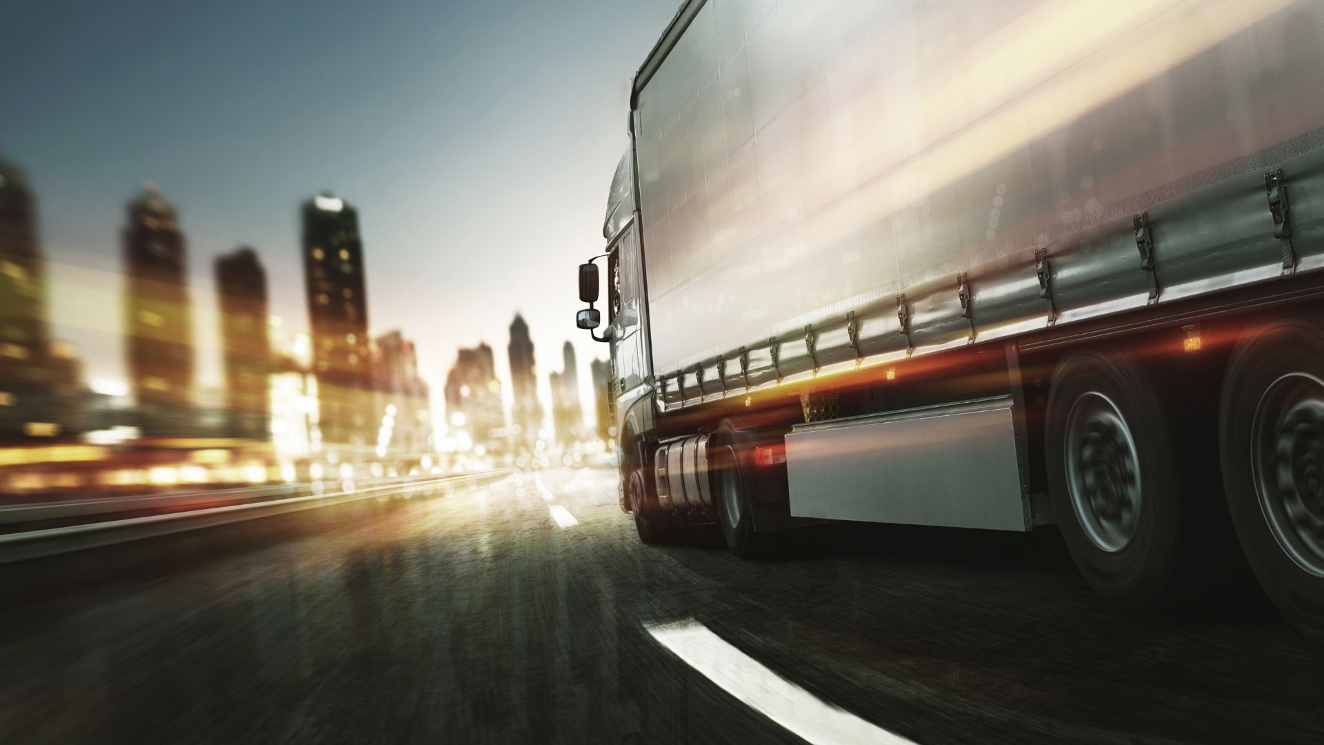 Semi Truck Driving on a Freeway with City in the Background