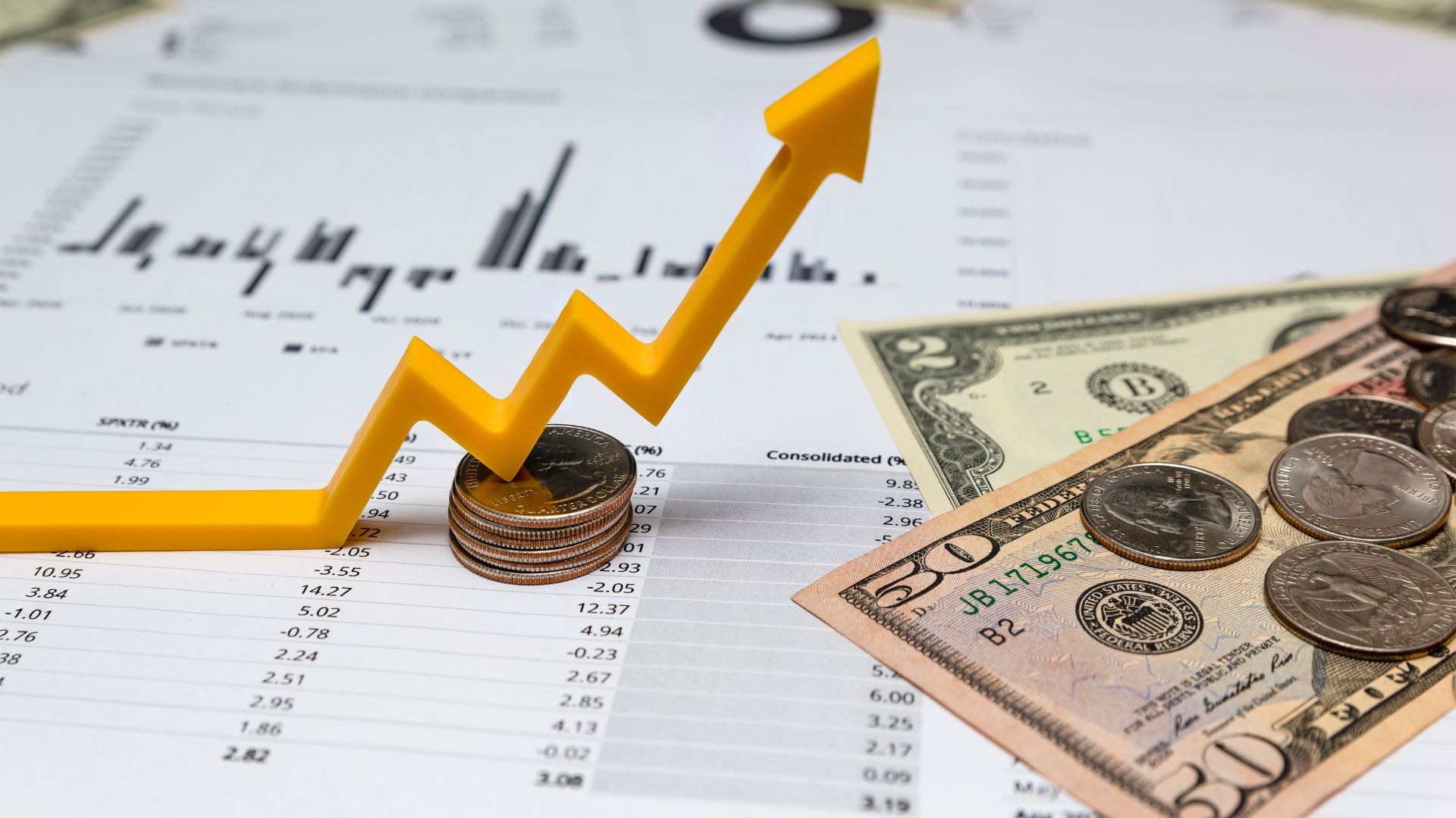 Money and Financial Documents on a Table with Yellow Upward Graph Area