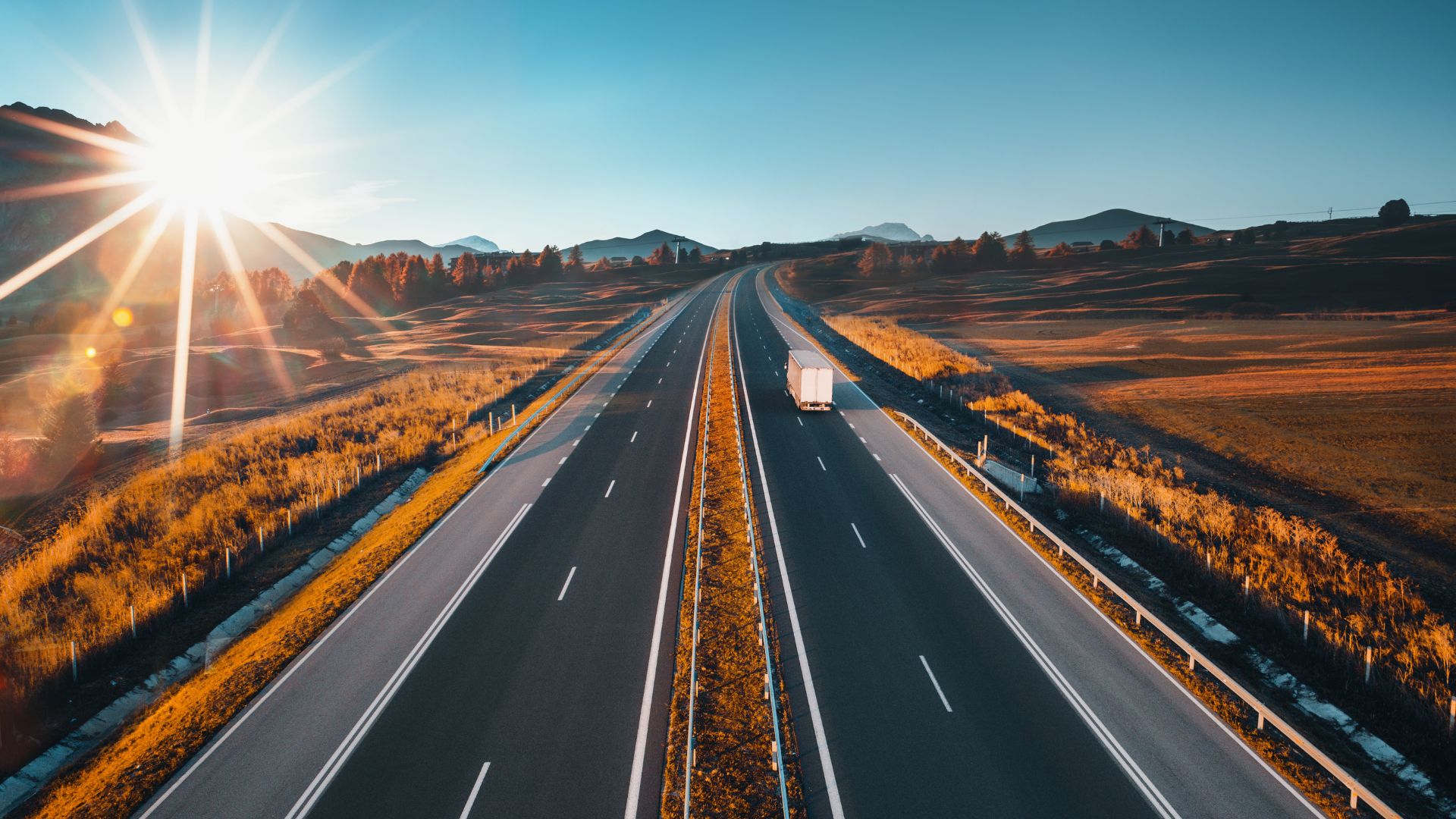Overhead View of Semi Truck on Wide Open Highway at Sunset