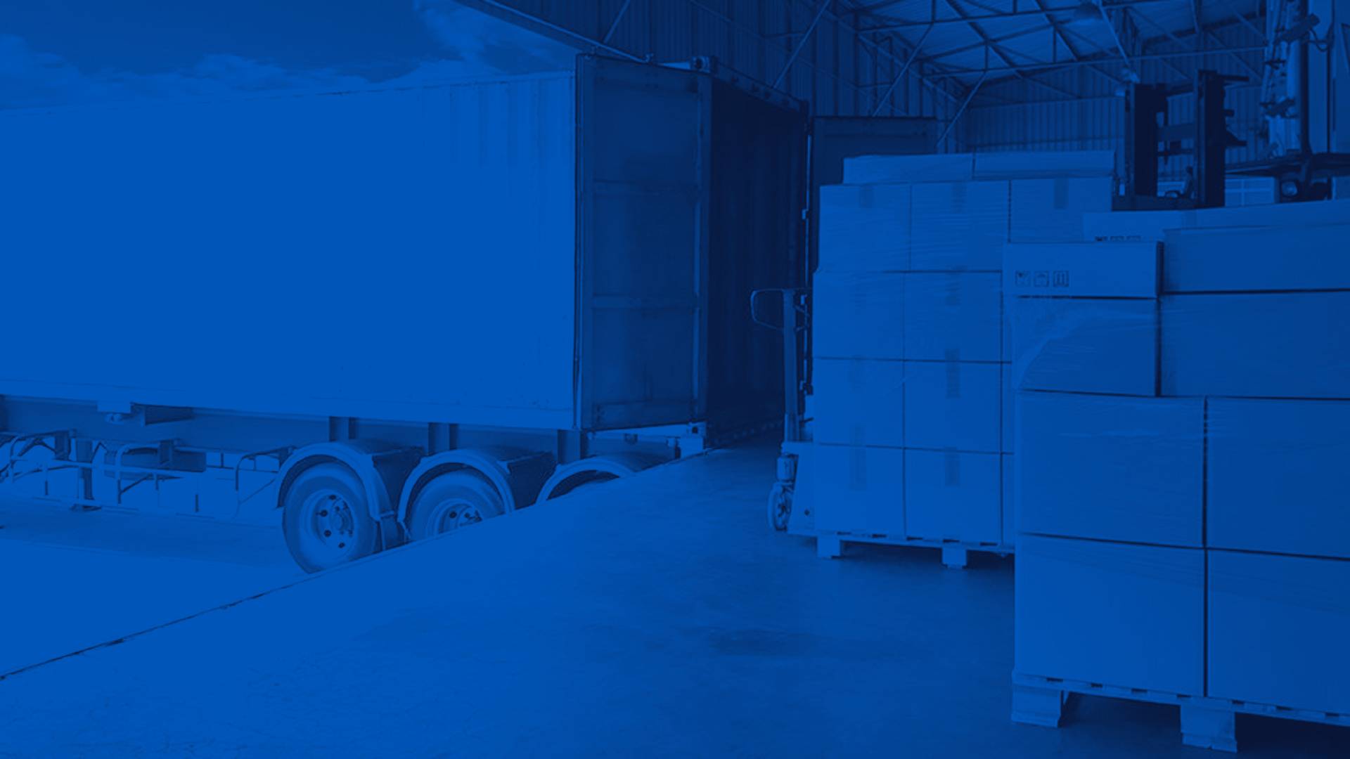 White Semi Truck at a Loading Dock Next to Pallets of Boxes