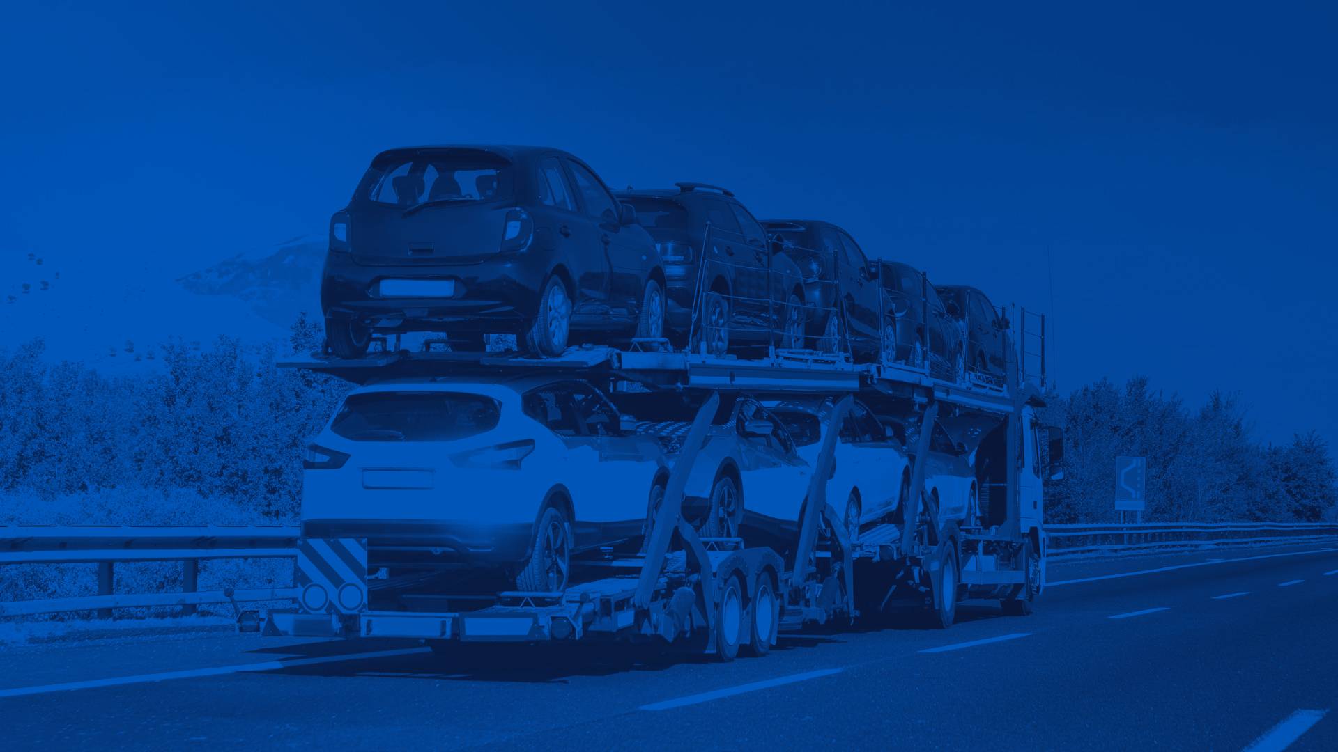 Semi Truck Hauling a Trailer of New Cars on a Highway