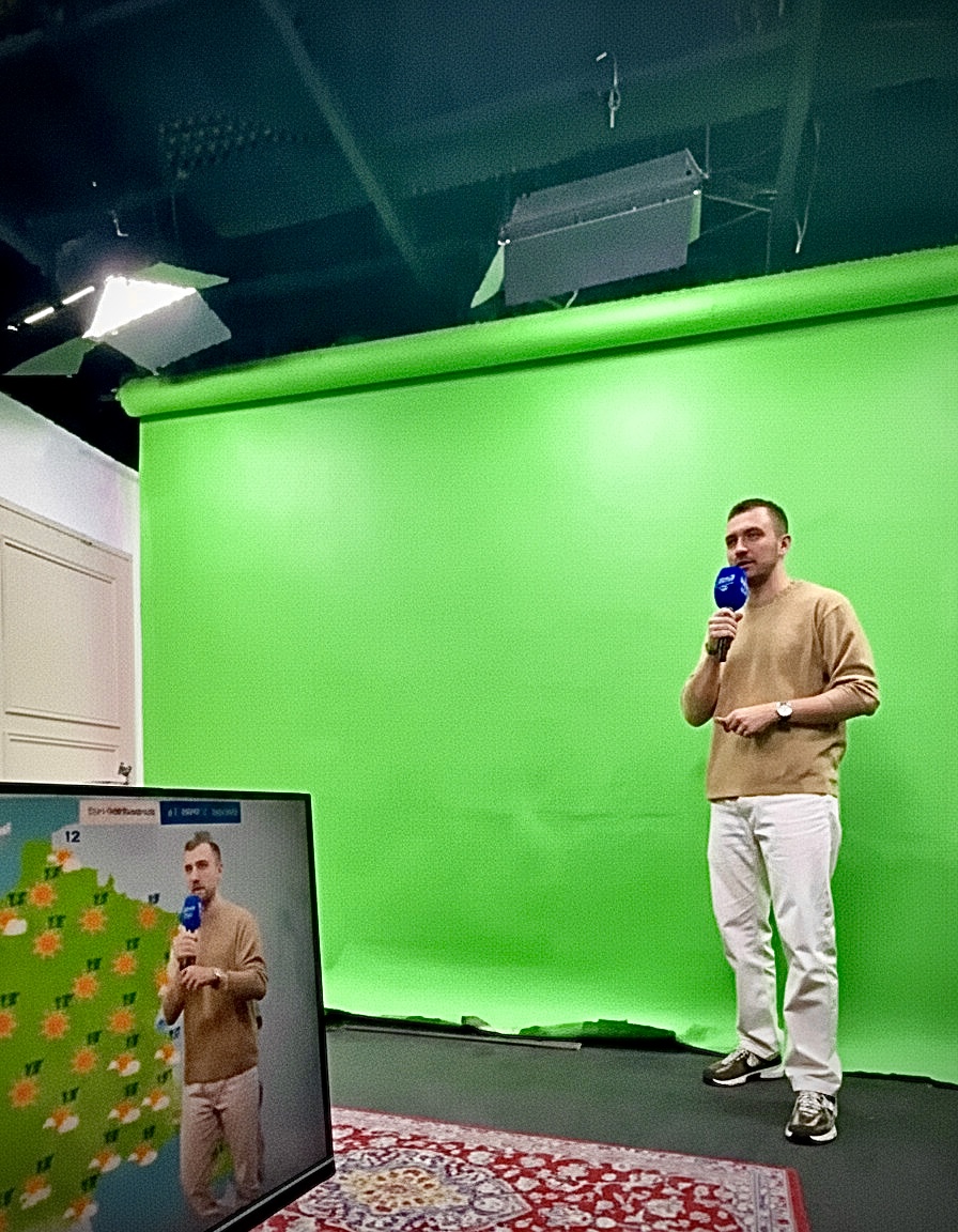 Une personne présente la météo devant un fond vert