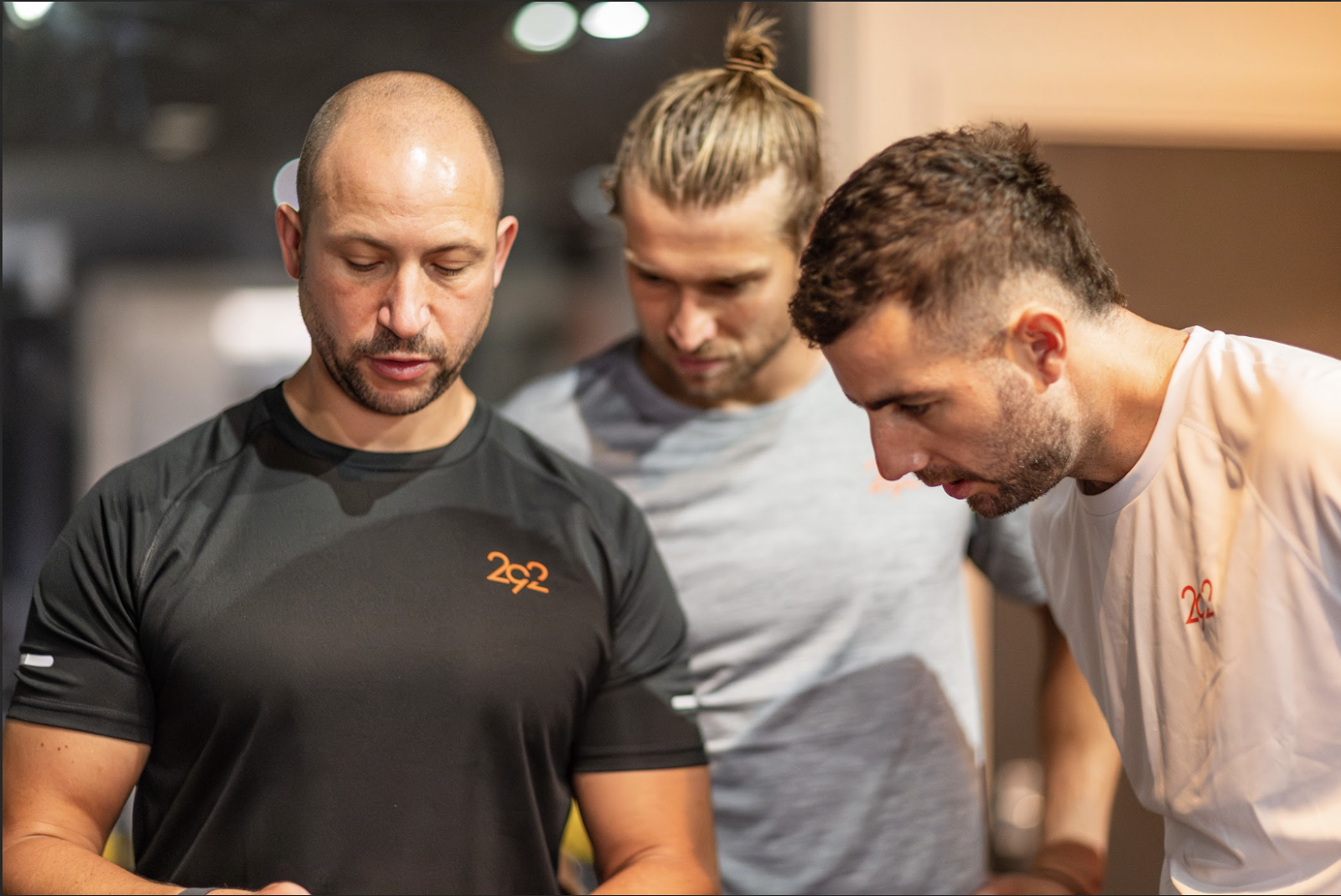 Image showing coach Ben Rosenblatt of 292 Performance with athletes looking over his shoulder displaying velocity tracking data on an ipad (out of shot)