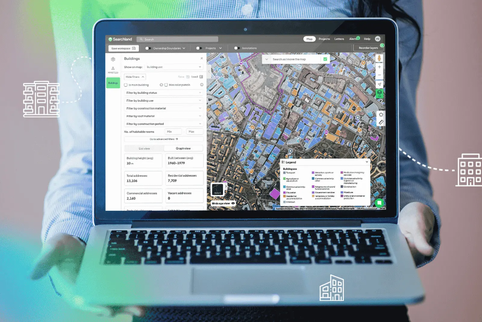 Person holding laptop showing Searchland UI