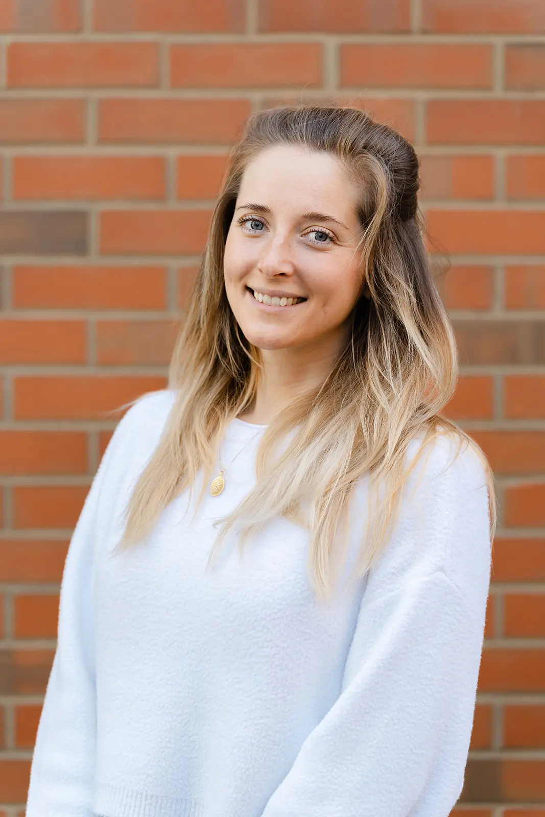Headshot of a woman against a brick wall