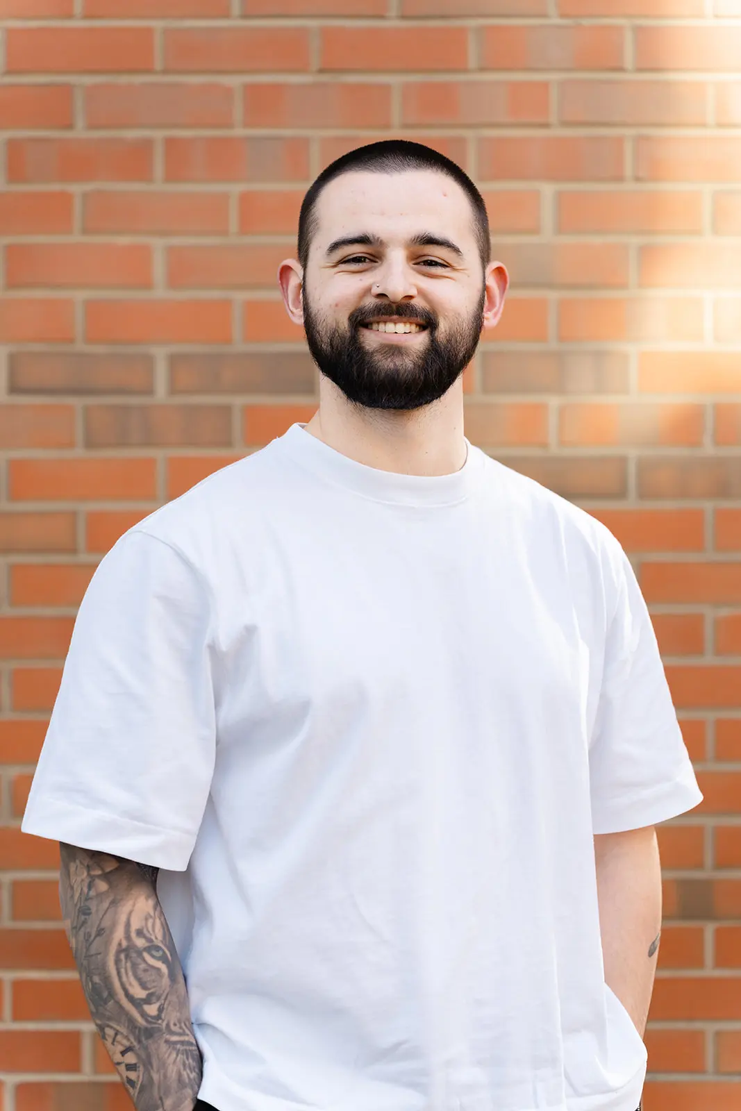 Male headshot against brick wall