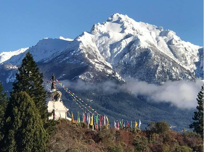 A snowy mountain with a white building and trees
