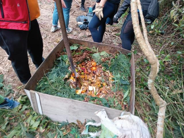 A group of people standing around a trash canAI-generated content may be incorrect.
