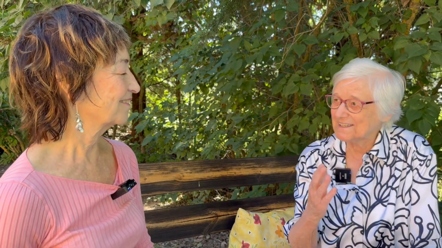 Two women sitting on a benchAI-generated content may be incorrect.