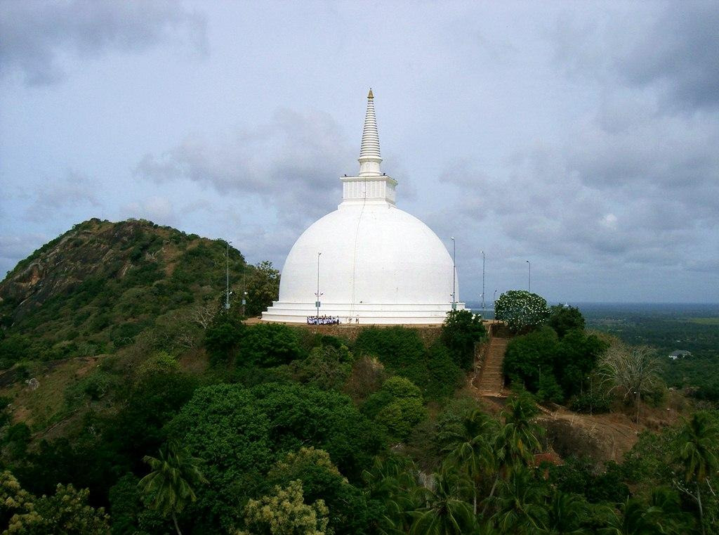 A white dome on a hill with Anuradhapura in the backgroundAI-generated content may be incorrect.