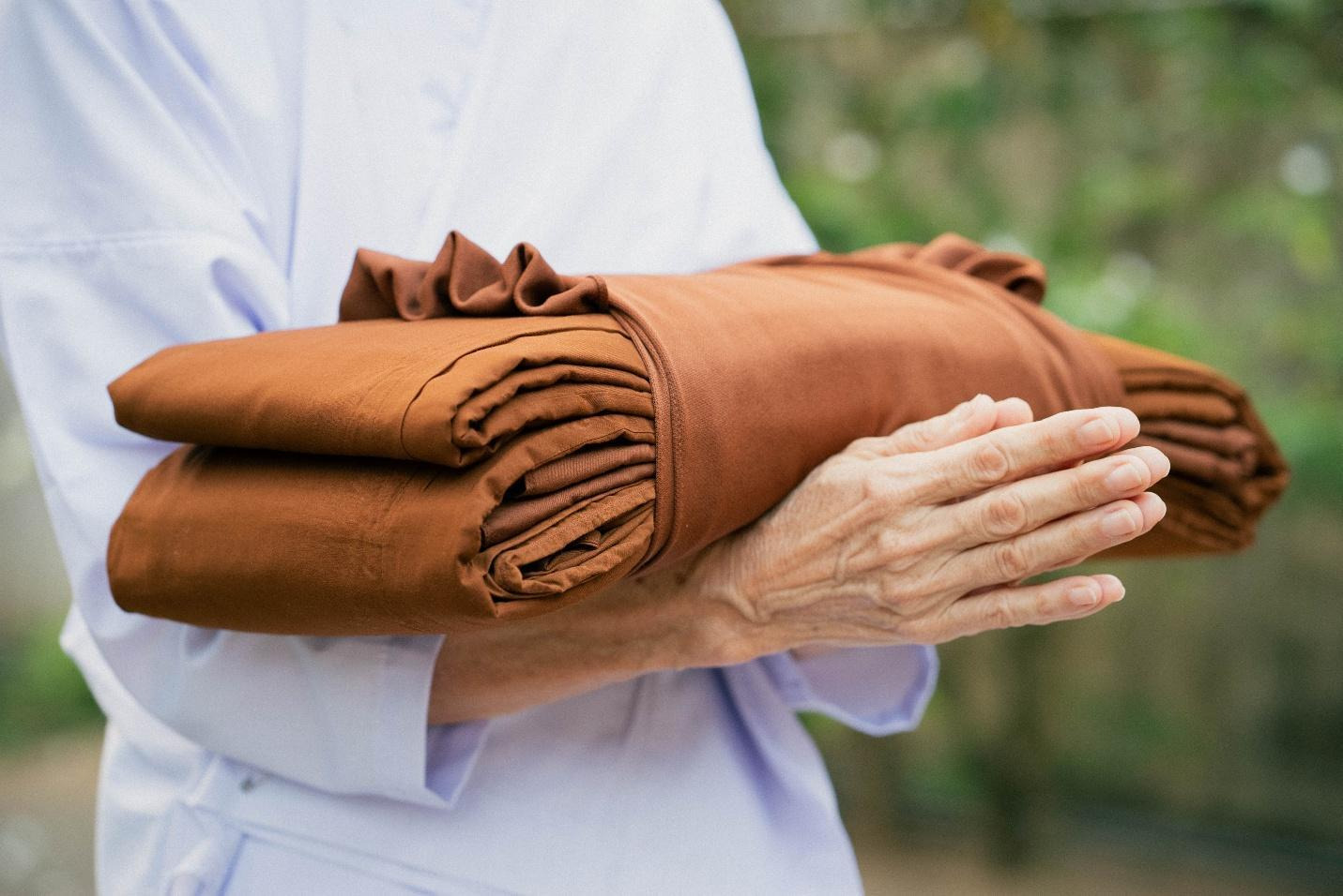 A person holding a folded blanketAI-generated content may be incorrect.