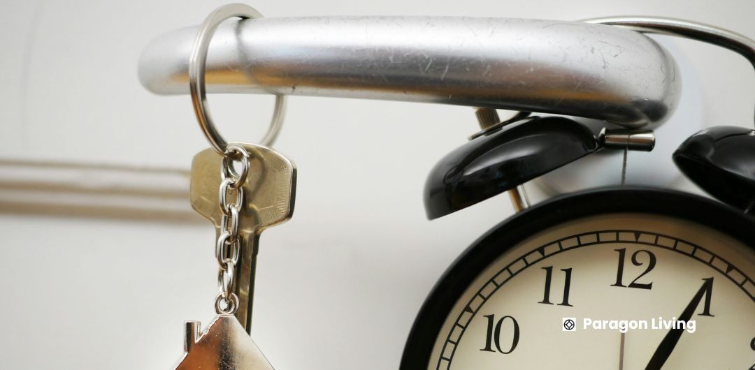 A clock and keys hanging from a door handle, symbolizing the renting timeline process in the UK.