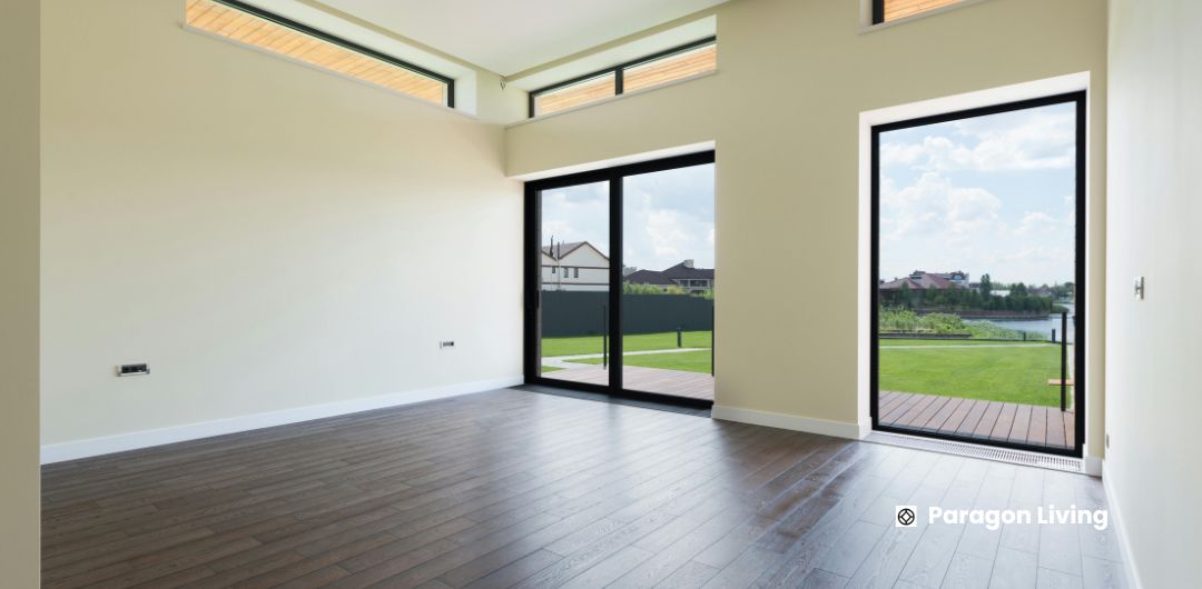 A spacious room featuring hardwood floors and large sliding glass doors, allowing natural light to fill the space.
