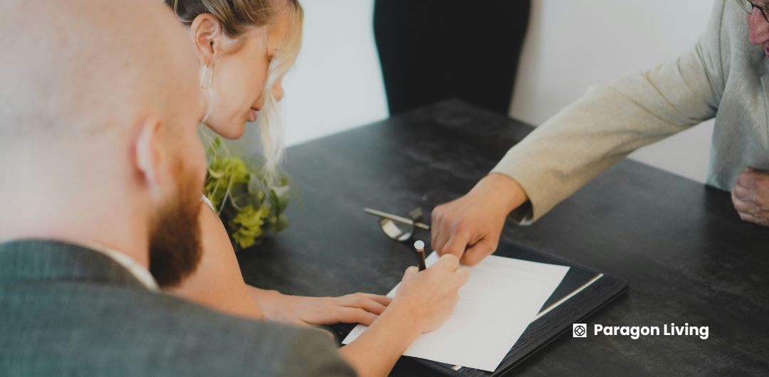 A man and woman at a desk, signing papers related to renting, with tips for making the process easier in the UK.