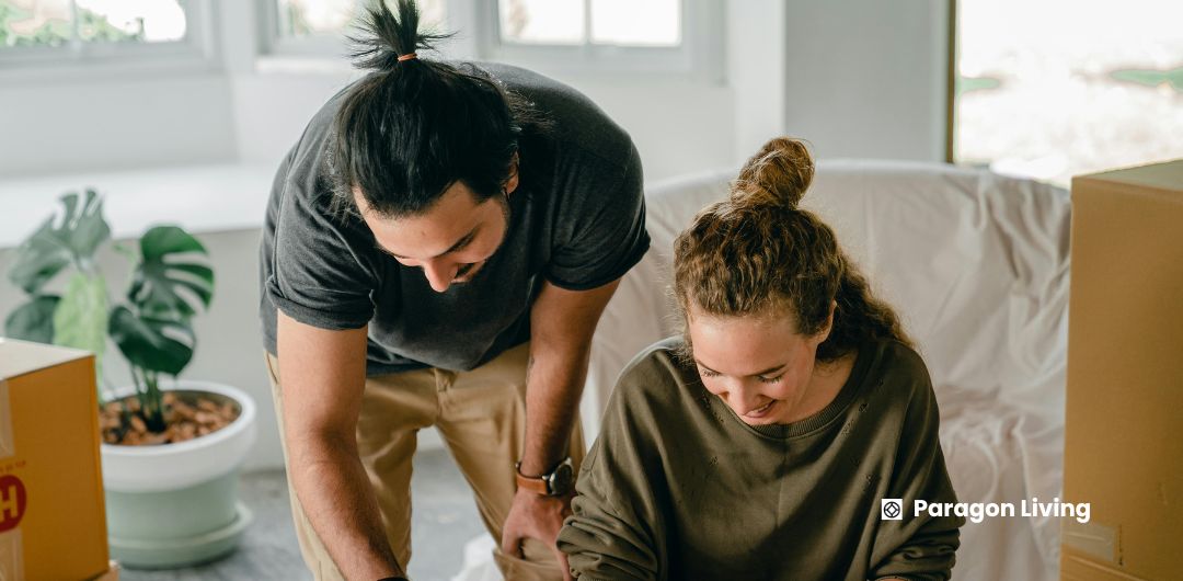 How to Rent a House in the UK (Step-by-Step): A man and woman are happily packing boxes together, preparing for their move while discussing renting a house in the UK.