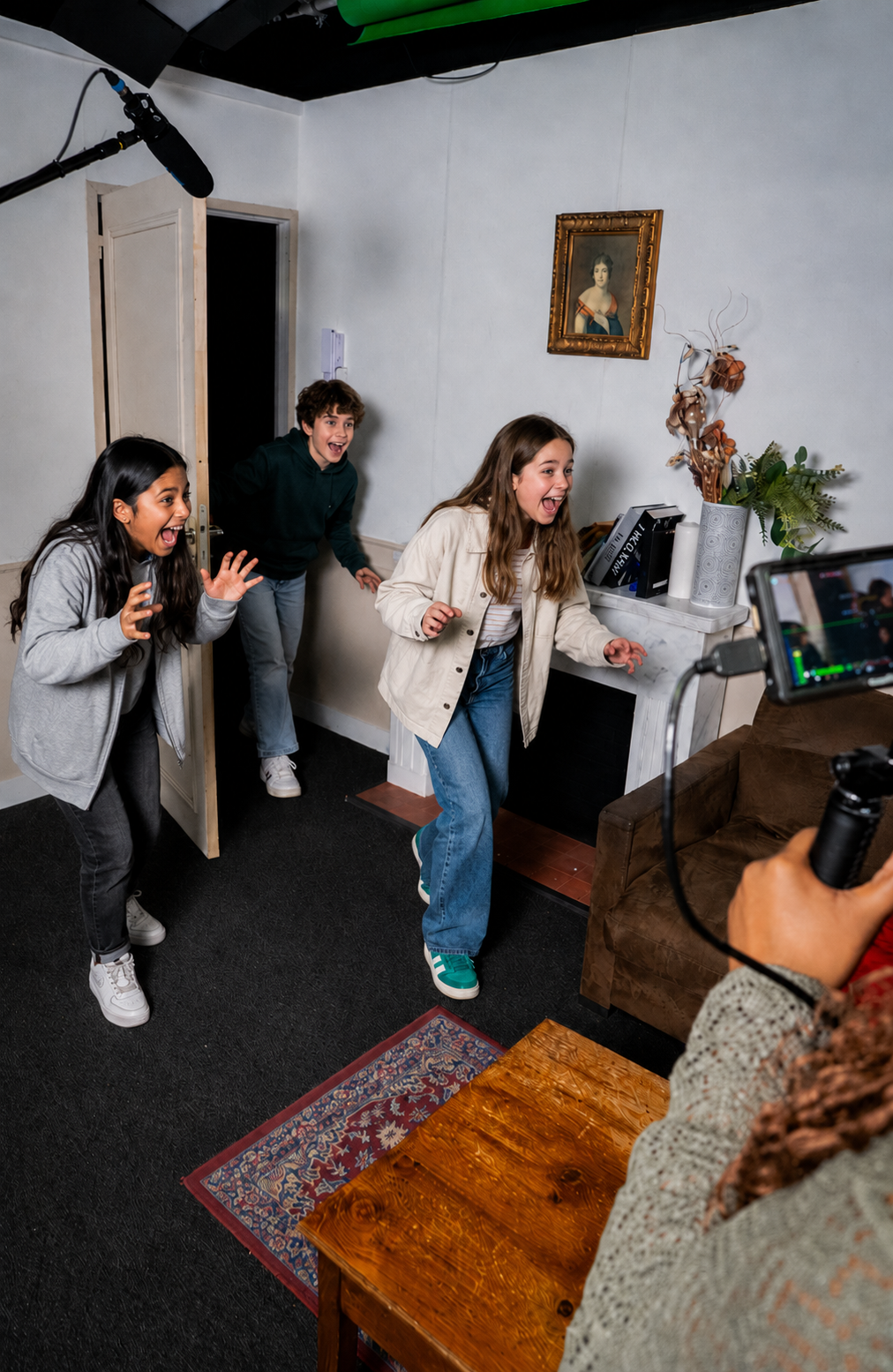 Un groupe d'enfant joue la comédie dans un décor d'appartement. Ils sont filmés.