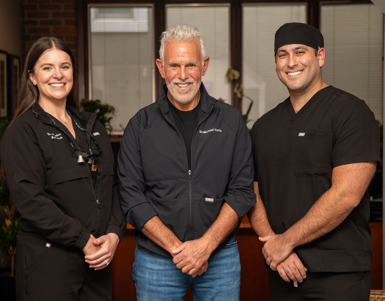 Drs Meaghan McCormick, Michael Santo, and Marcus Santo are standing next to each other and smiling