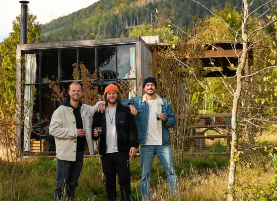 Amis posant devant une cabane en automne