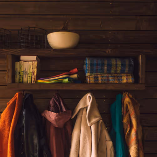 Raincoats, books, hot water bottles, plaids and a decorative bowl all together in one of the Nutchel Cosy Cabins