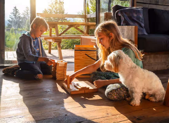 Kids playing with their dog in a cabin in the woods during holidays with kids
