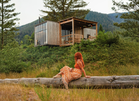 A woman who loves to travel alone is relaxing in front of one of the Nutchel Cosy Cabins