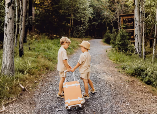 Two kids going to their Nutchel cosy cabin with a suitcase