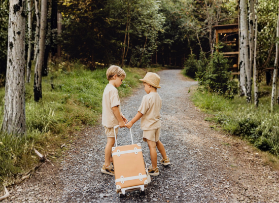 Two kids going to their Nutchel cosy cabin with a suitcase