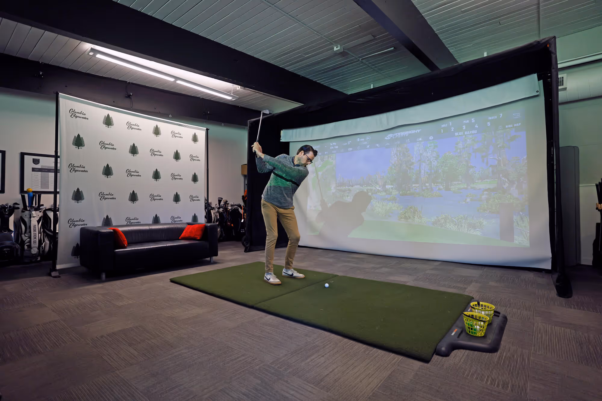 Male golfer practices his swing in the Pro Shop's golf simulator