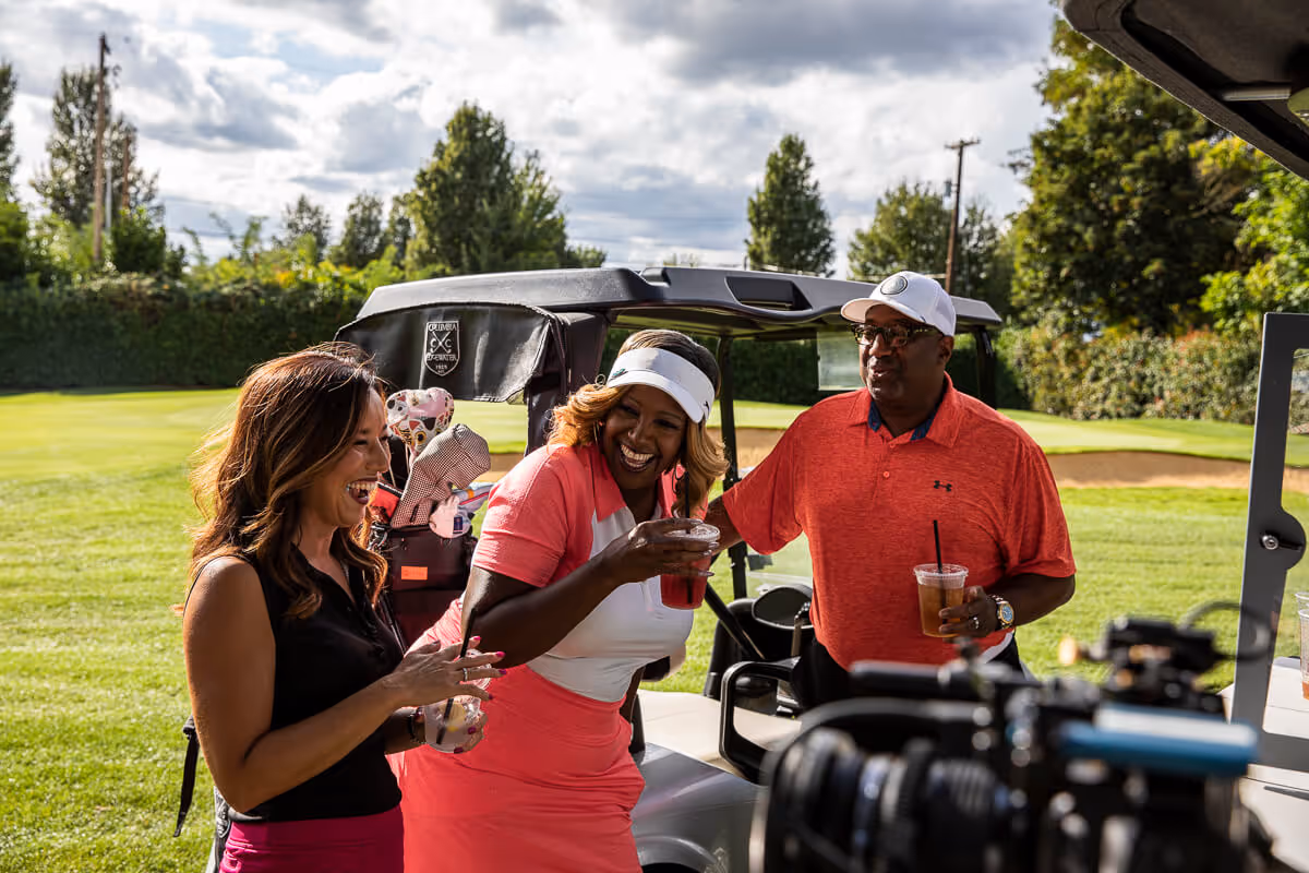 Group of golfers laugh and enjoy refreshments on the course at Columbia Edgewater