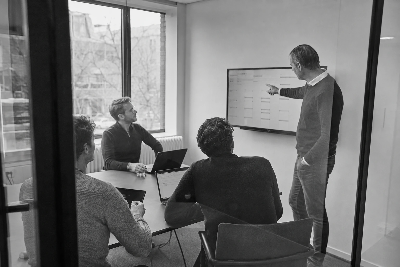 A working session around a planning screen, shown as editorial illustration