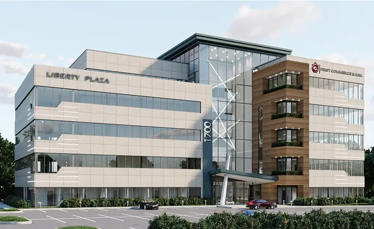 Modern office building labeled Tower 3 with large glass facade and several parked cars in front under a clear sky.