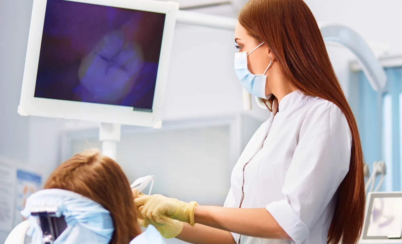 A woman getting her teeth checked by a dentist.